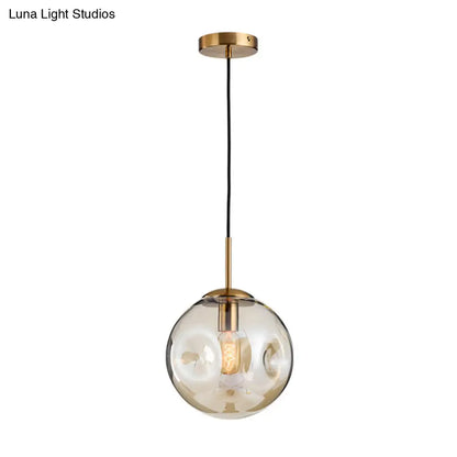 Postmodern Brass Pendant Lamp with Dimpled Glass Globe for Bedroom