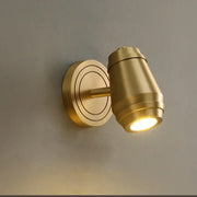 Postmodern brass wall lamp with cylindrical spotlight and concentric circular base for bedroom decorbites brass wall lamp