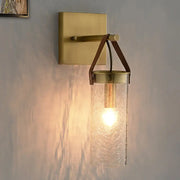 Postmodern brass wall sconce with clear crack glass cylinder and leather strap accents for dining room lighting