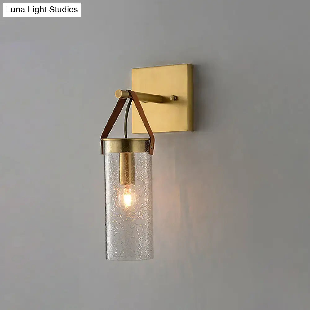 Postmodern brass wall sconce with clear crack glass cylinder and brown leather strap for dining room lighting