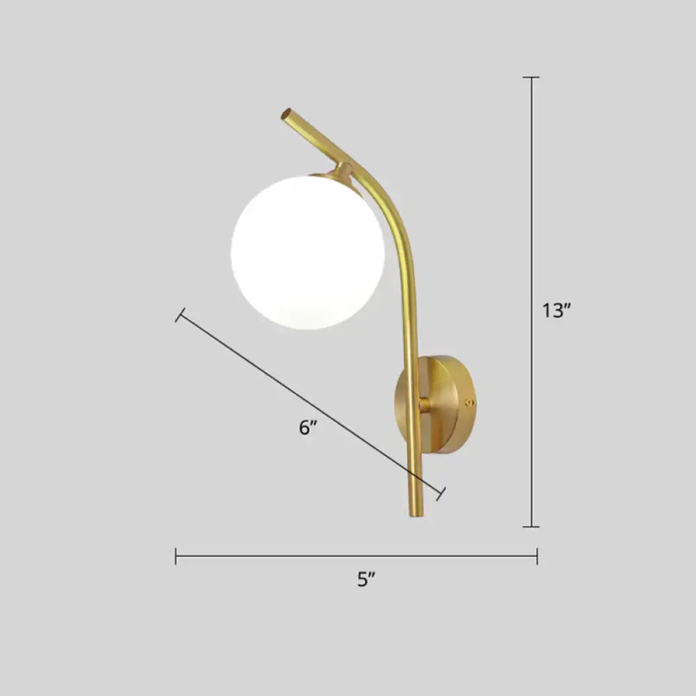 Postmodern brass wall sconce with gold-toned curved arm and white glass geometric frosted spherical shade for living room