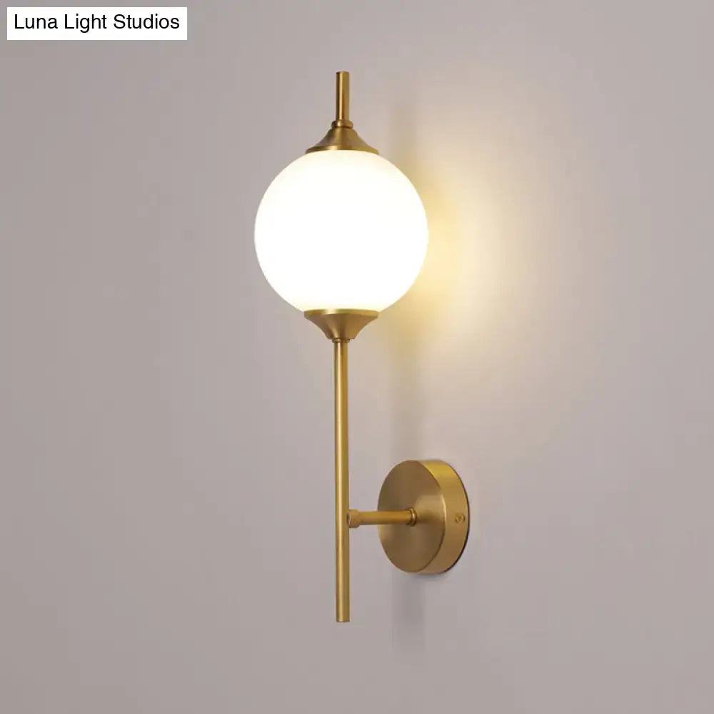 Postmodern brass wall sconce with white glass geometric frosted globe and minimalist metal arms for living room use
