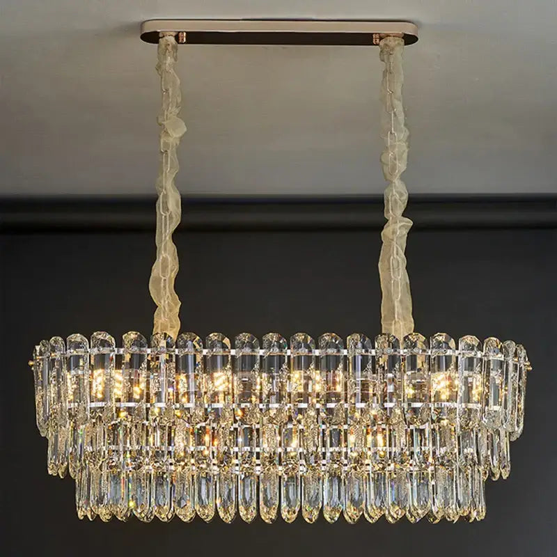 Postmodern decorbites crystal chandelier with clear prisms and gold-toned metal, suspended by cream cords for dining room
