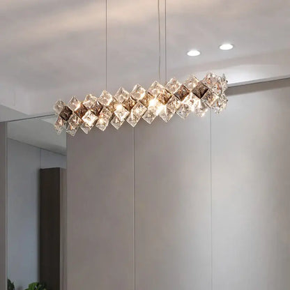 A modern elongated decorbites crystal chandelier with clear and smoky cubes in a zigzag pattern for living room