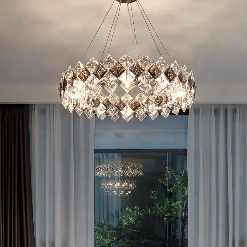 A modern decorbites crystal chandelier with clear and smoky faceted glass in overlapping diamond patterns for living rooms