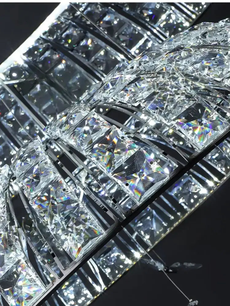 A postmodern pendant light featuring a crystal butterfly design with clear faceted crystals on a black metal frame