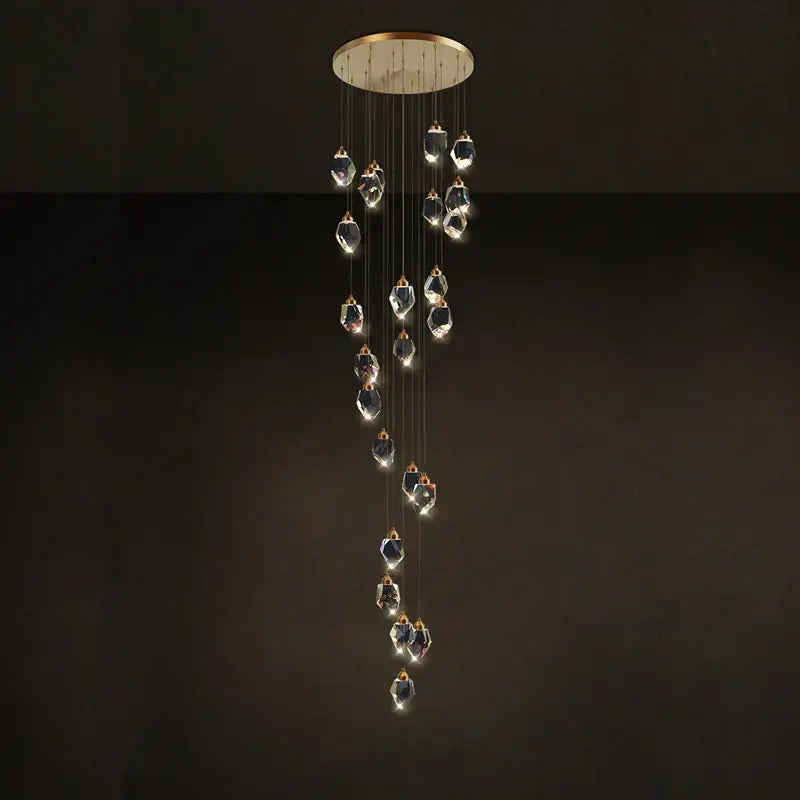 A postmodern crystal stone copper chandelier with gold-toned mount and cascading clear glass pendants for staircase lighting