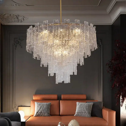 A modern decorbites crystal chandelier with cascading frosted glass panels and a gold-toned rod for dining rooms