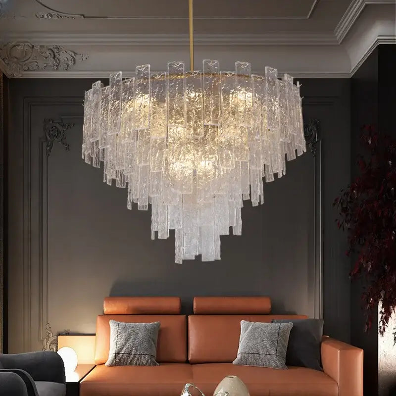 A modern decorbites crystal chandelier with cascading frosted glass panels and a gold-toned rod for dining rooms