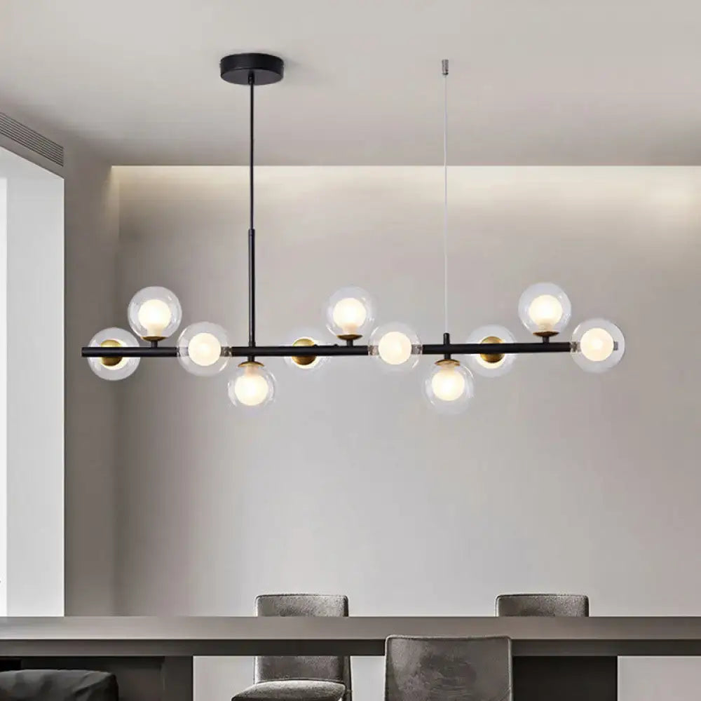 Modern black metal pendant light with clear glass globe bulbs and gold-toned accents for kitchen lighting