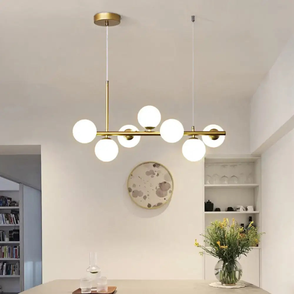 Modern brass pendant light with six frosted glass globe bulbs in linear design from decorbites postmodern collection