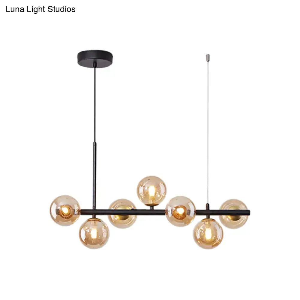 Modern black metal pendant light with seven amber glass globe bulbs from DecorBites™ for kitchen use