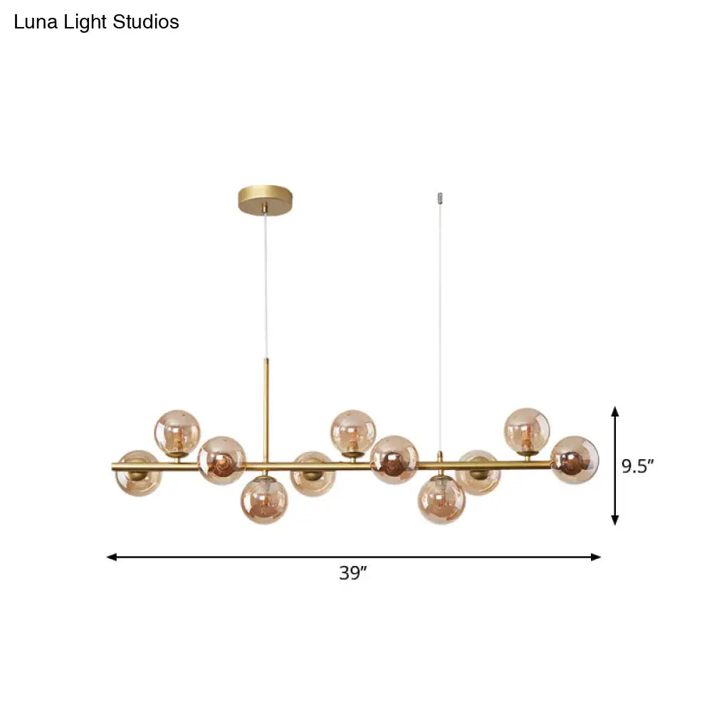 Gold-toned modern pendant light with amber glass globe bulbs on a sleek bar from DecorBites™ postmodern series