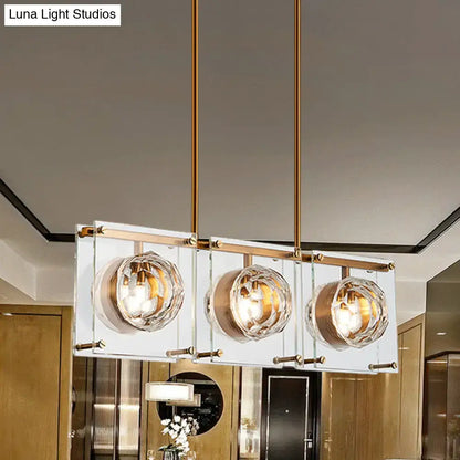 Postmodern gold and clear glass 3-light kitchen island light with rectangular brass rods and faceted crystal globe shades
