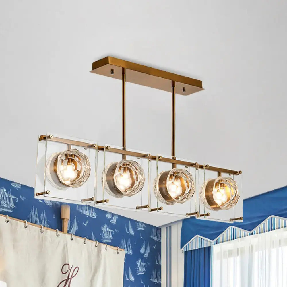 Modern brass-finished rectangular pendant kitchen island light with four clear crystal globe shades for kitchen island