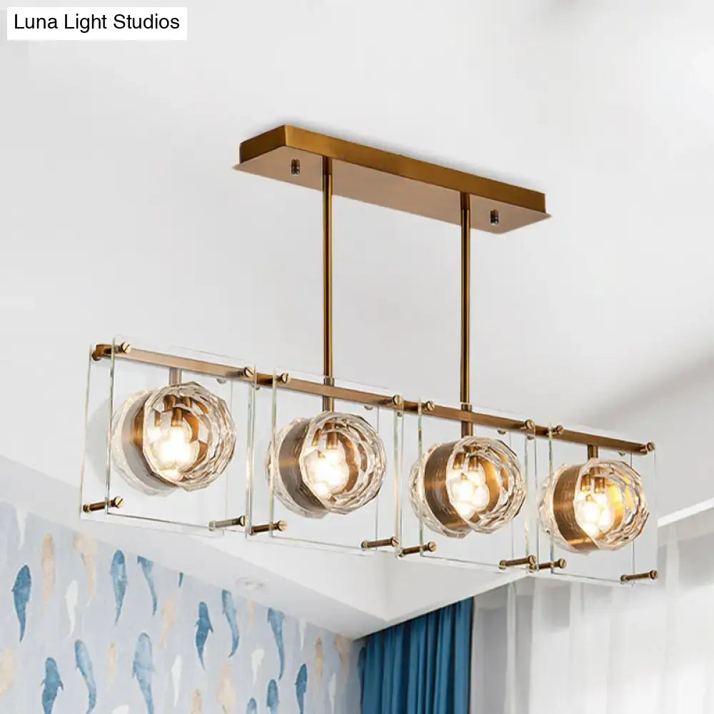 Modern brass finished rectangular kitchen island light with four clear faceted glass globes and warm-toned bulbs