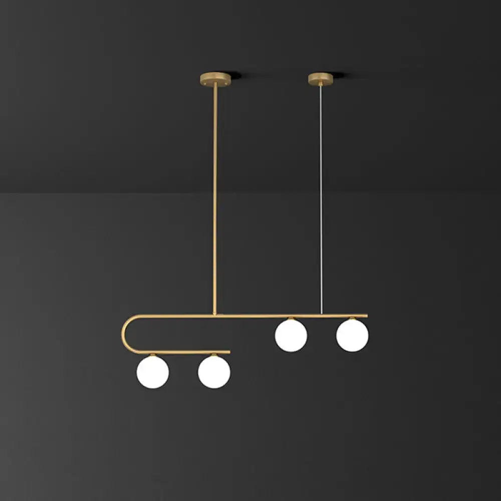 DecorBites postmodern gold linear island pendant light with curved metal frame and four ivory ball glass bulbs