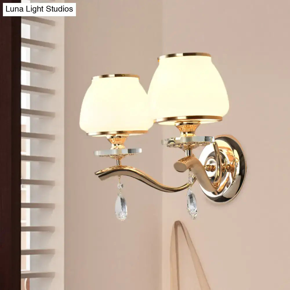 Postmodern gold finished direct wired wall sconce with white glass shades and crystal drop accents for bedroom lighting