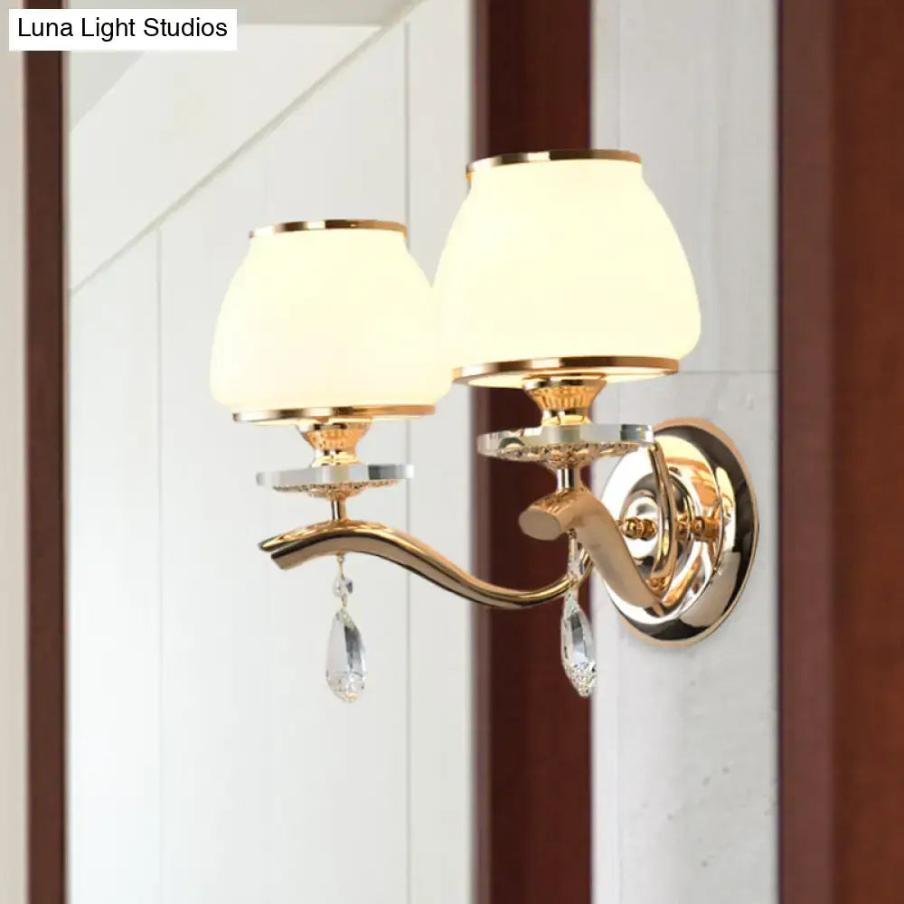 Postmodern gold finished direct wired wall sconce with white glass shades and crystal drop accents for bedroom lighting