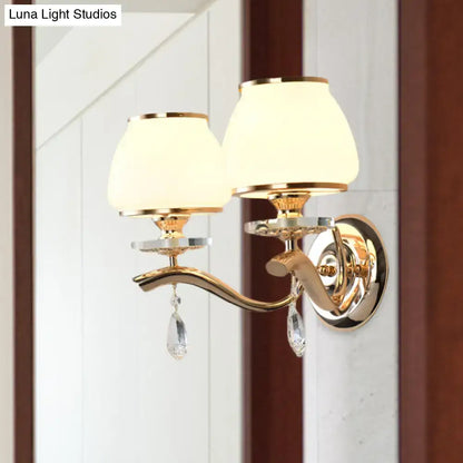 Postmodern gold finished direct wired wall sconce with white glass shades and crystal drop accents for bedroom lighting