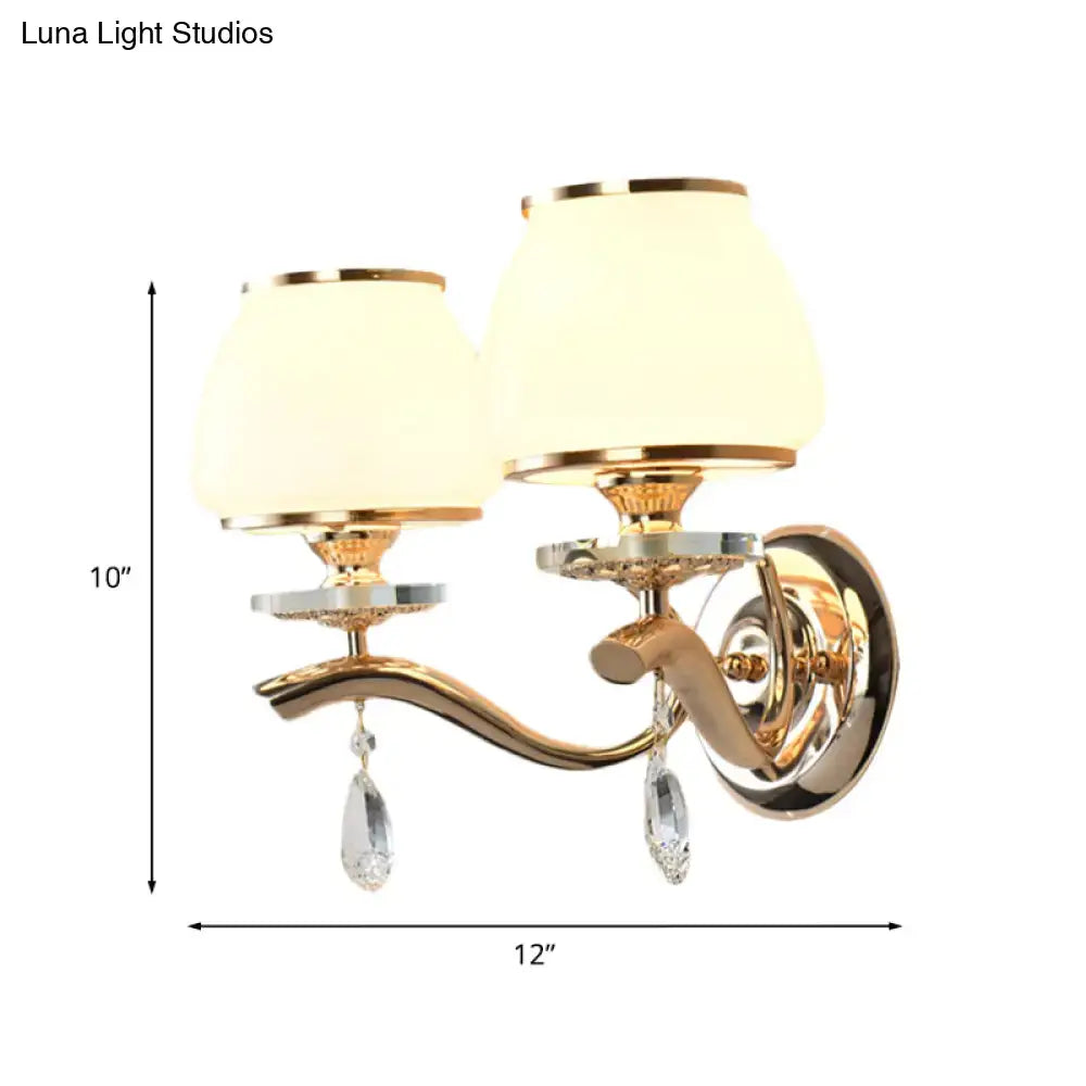 Postmodern gold wall sconce with direct wired crystal drop and white glass shades for bedroom lighting