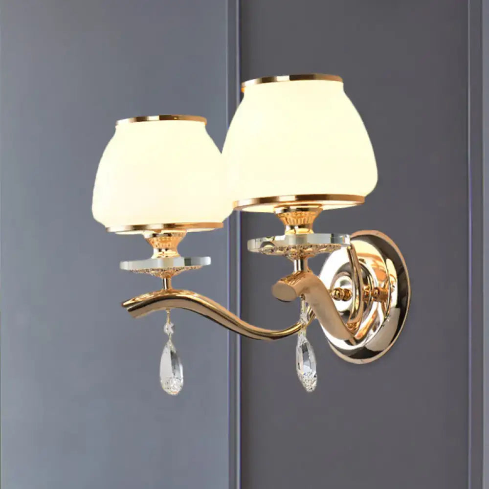 Postmodern gold finished double-arm direct wired wall sconce with white glass shades and crystal drop pendants for bedroom light
