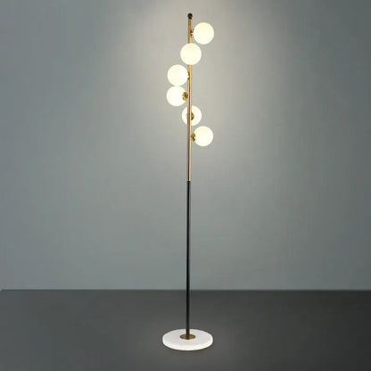 Postmodern gold and black glass floor lamp with five glowing white spherical bulbs and circular marble base for living room