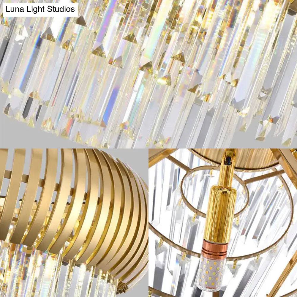 A postmodern gold crystal oval chandelier with cascading clear crystal prisms and a sleek gold-toned metal frame