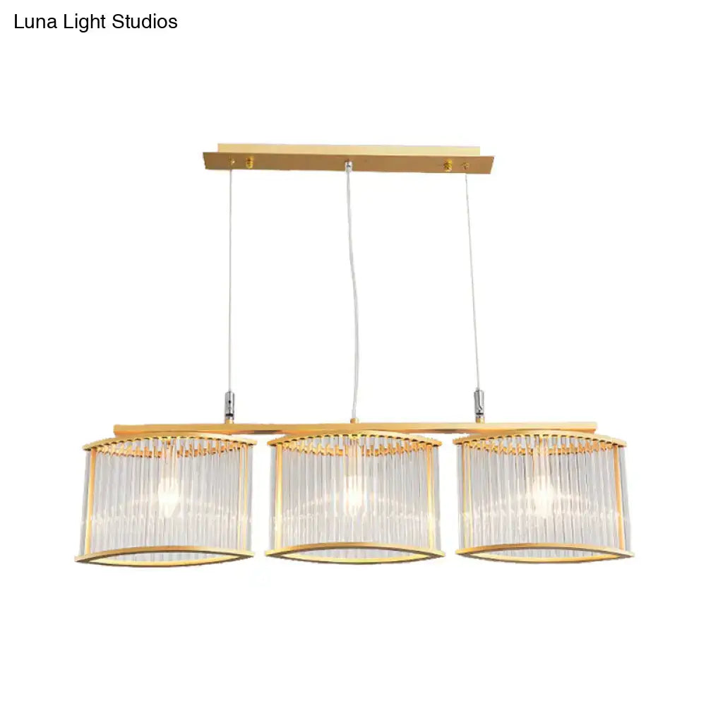 Gold-toned postmodern rod island light with three cylindrical glass shades and crystal rods for dining room island lighting