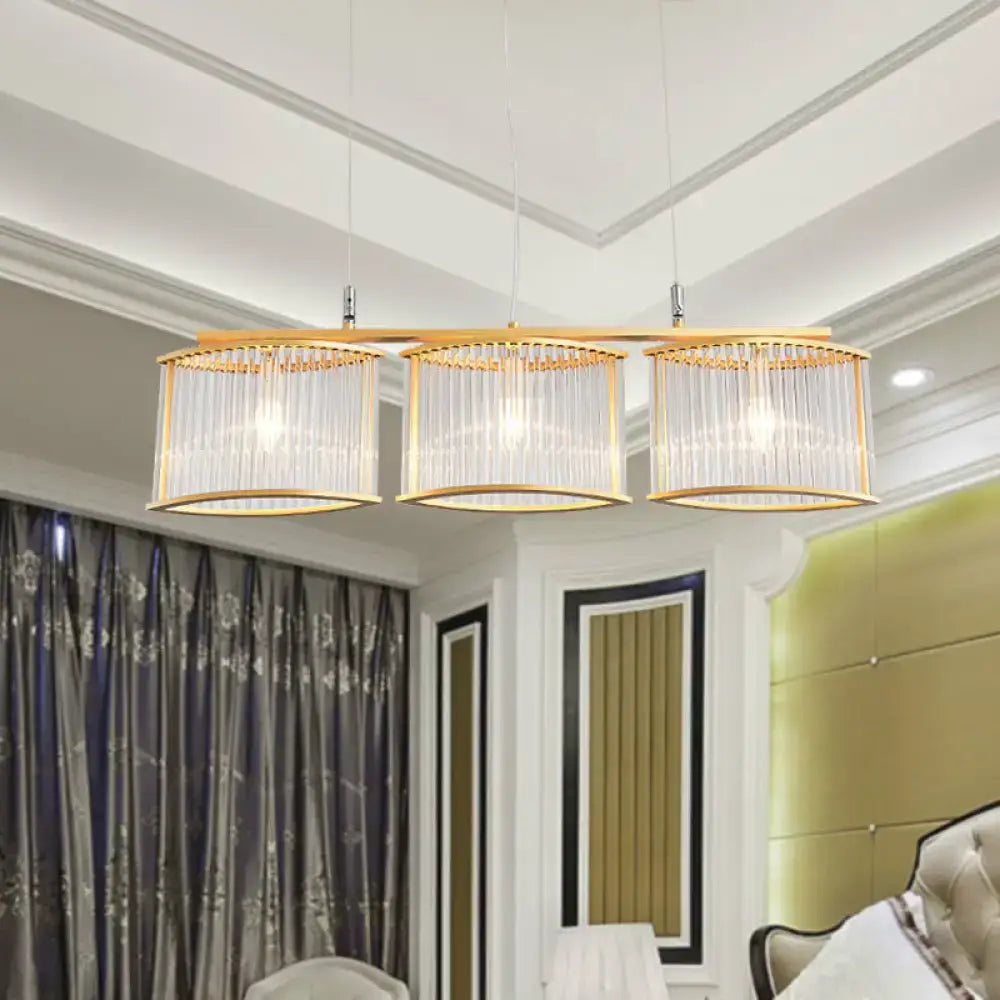 Gold-toned pendant chandelier with three cylindrical shades and vertical crystal rods for dining room island light postmodern