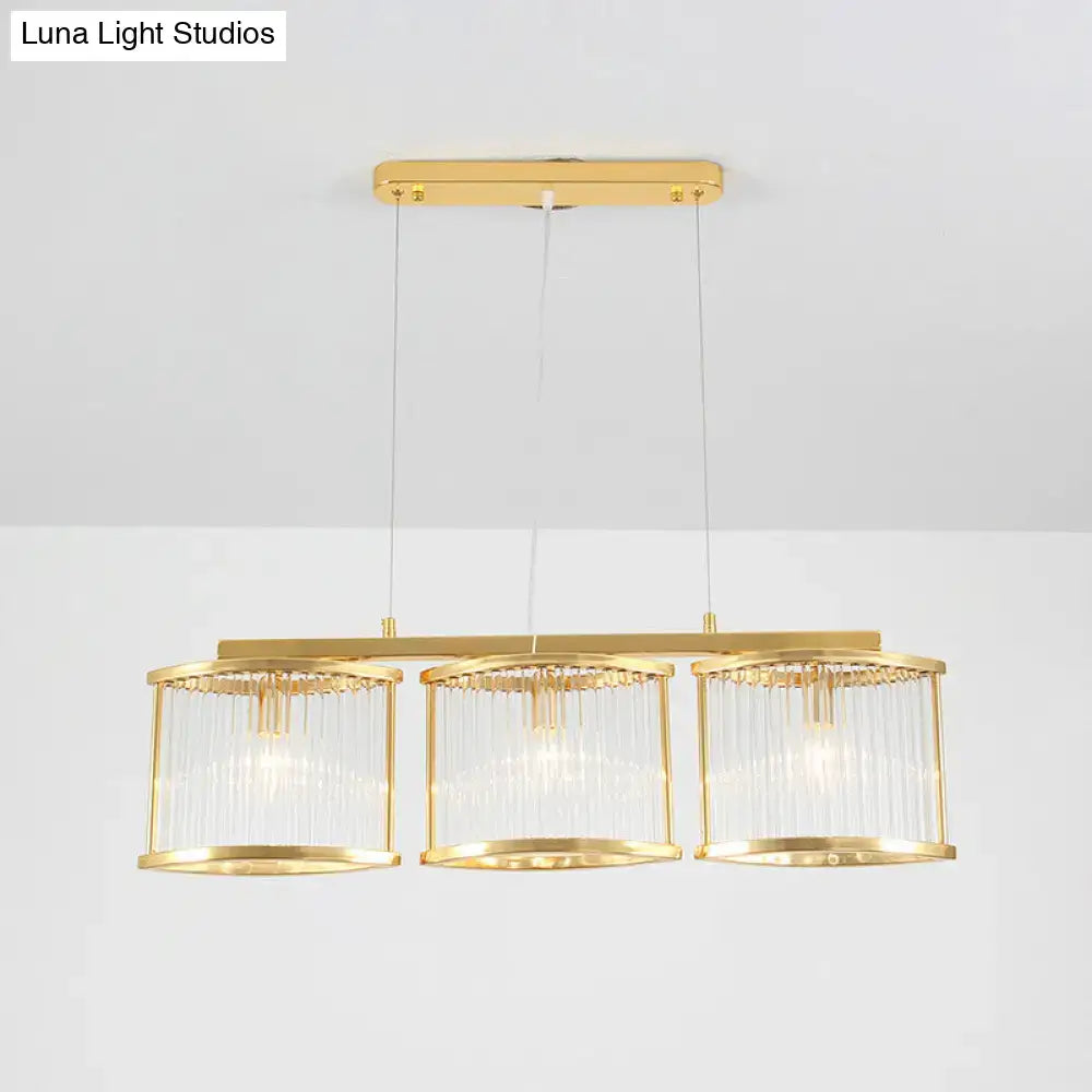 Postmodern gold crystal rod island light with three cylindrical glass shades and sleek metal frame for dining room