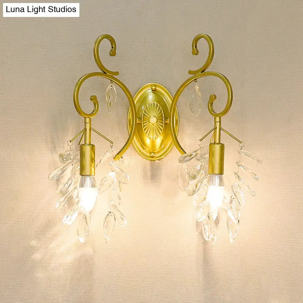Postmodern gold curve arm sconce light with crystal leaf accents and two exposed bulbs for living room use