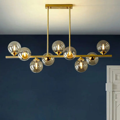 مصباح معلق على شكل كرة زجاجية كهرمانية بلمسة نهائية ذهبية من DecorBites™ بتصميم ما بعد الحداثة لإضاءة الطاولة