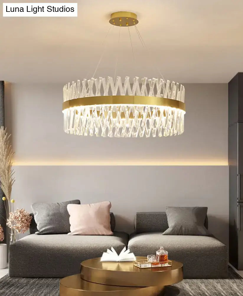A modern pendant light with gold finish and k9 crystal elements in a geometric circular fixture width design