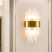 Postmodern gold-toned wall sconce with clear fluted crystal rods and a circular base designed for 110v-120v use