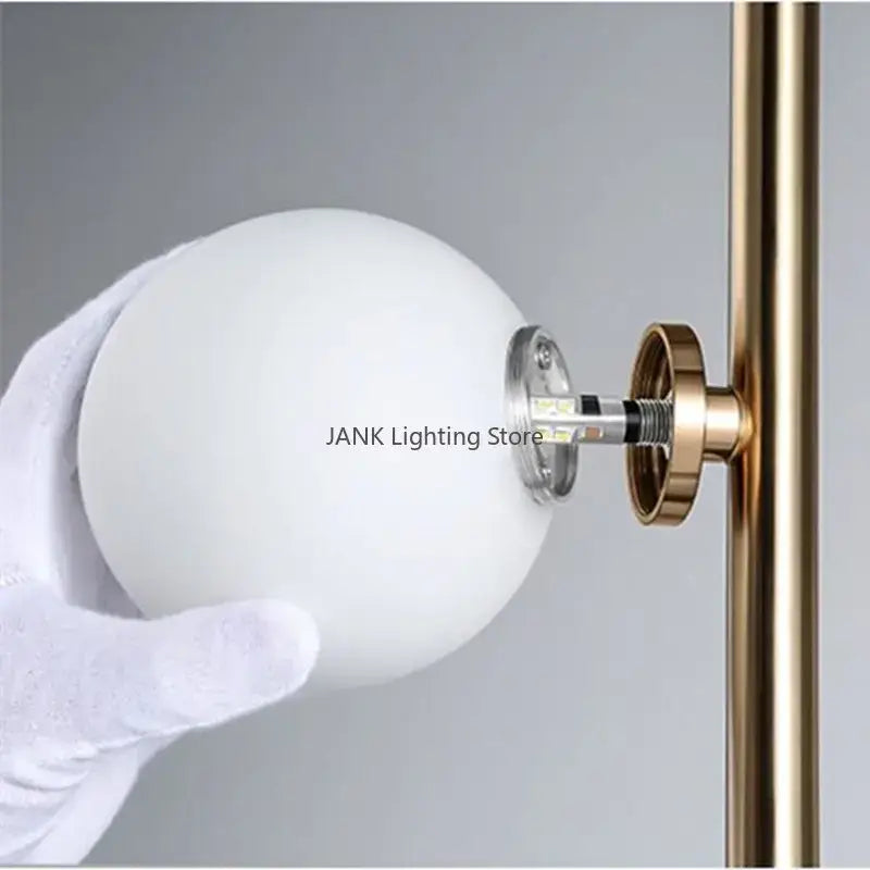 Postmodern gold decorbites glass ball standing lamp with white frosted glass globe on brass-finished pole for living room