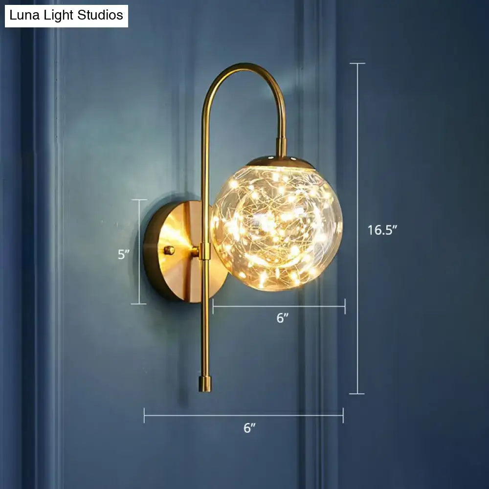 Postmodern gold-toned glass globe wall light fixture with warm glowing fairy lights for bedroom ambiance
