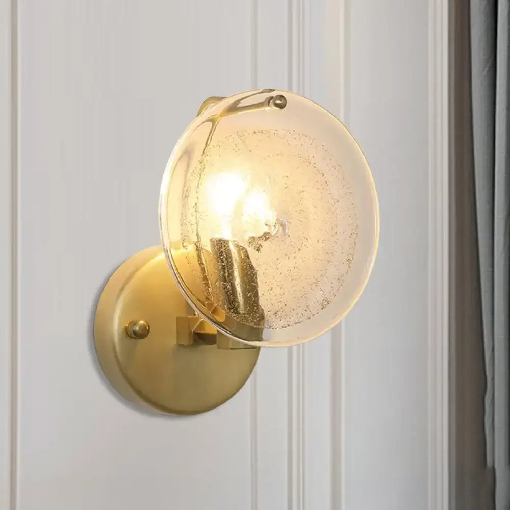 Postmodern gold metal wall sconce with frosted glass shade featuring subtle internal bubbles for bedroom light