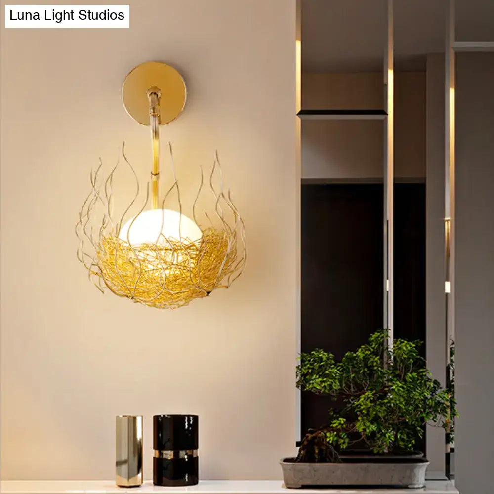 Postmodern gold nest globe glass wall light fixture with spherical bulb in flame-like wire cage for bedroom sconce