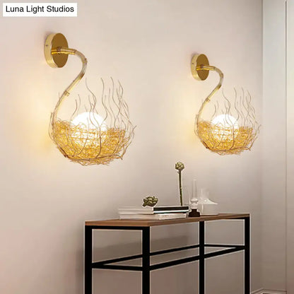 Postmodern gold-toned glass wall light fixture with intricate wire nest design housing warm glowing globe bulbs