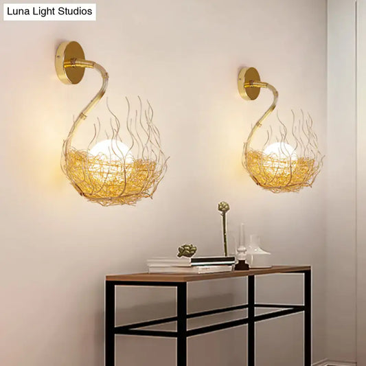 Postmodern gold-toned glass wall light fixture with intricate wire nest design housing warm glowing globe bulbs