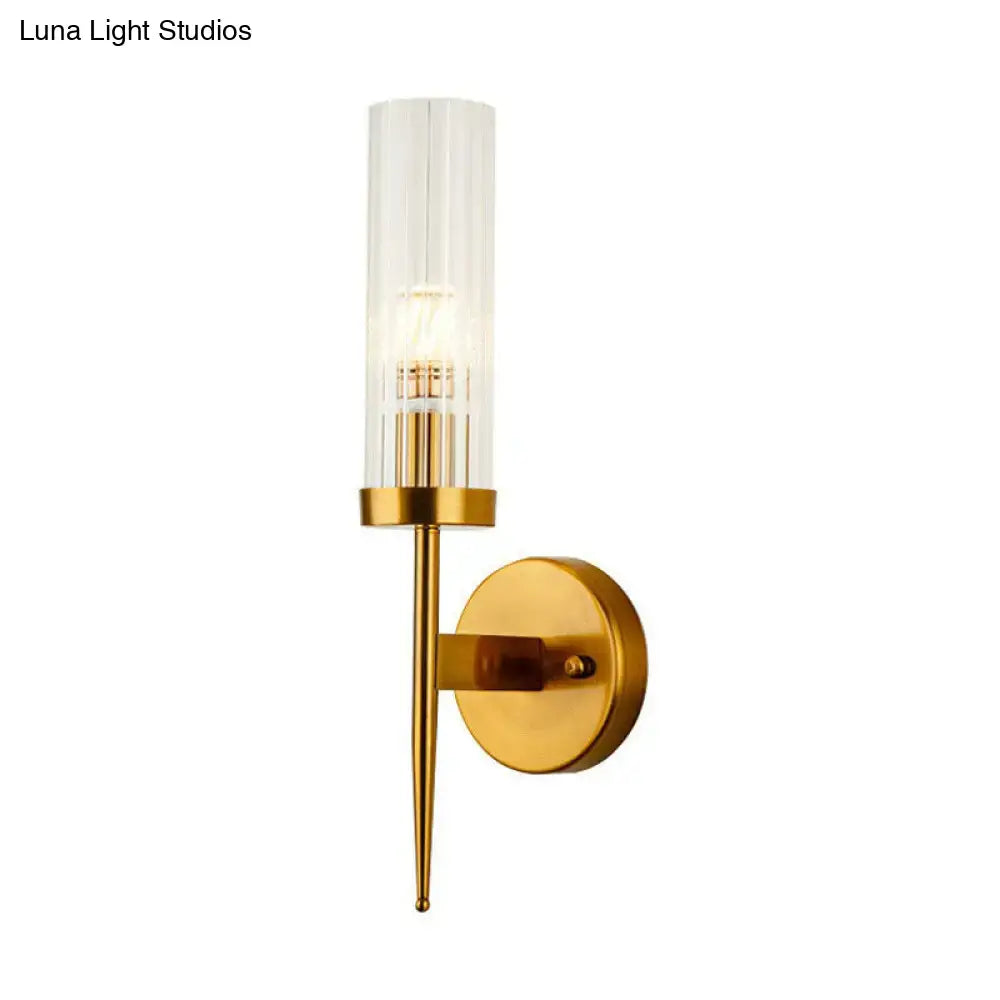 Postmodern gold-toned wall sconce with clear ribbed glass cylindrical shade and slender metallic stem for stairway lighting