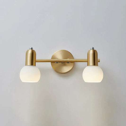 Postmodern gold-toned wall sconce with two frosted dome milk glass shades for milk glass vanity or bathroom lighting