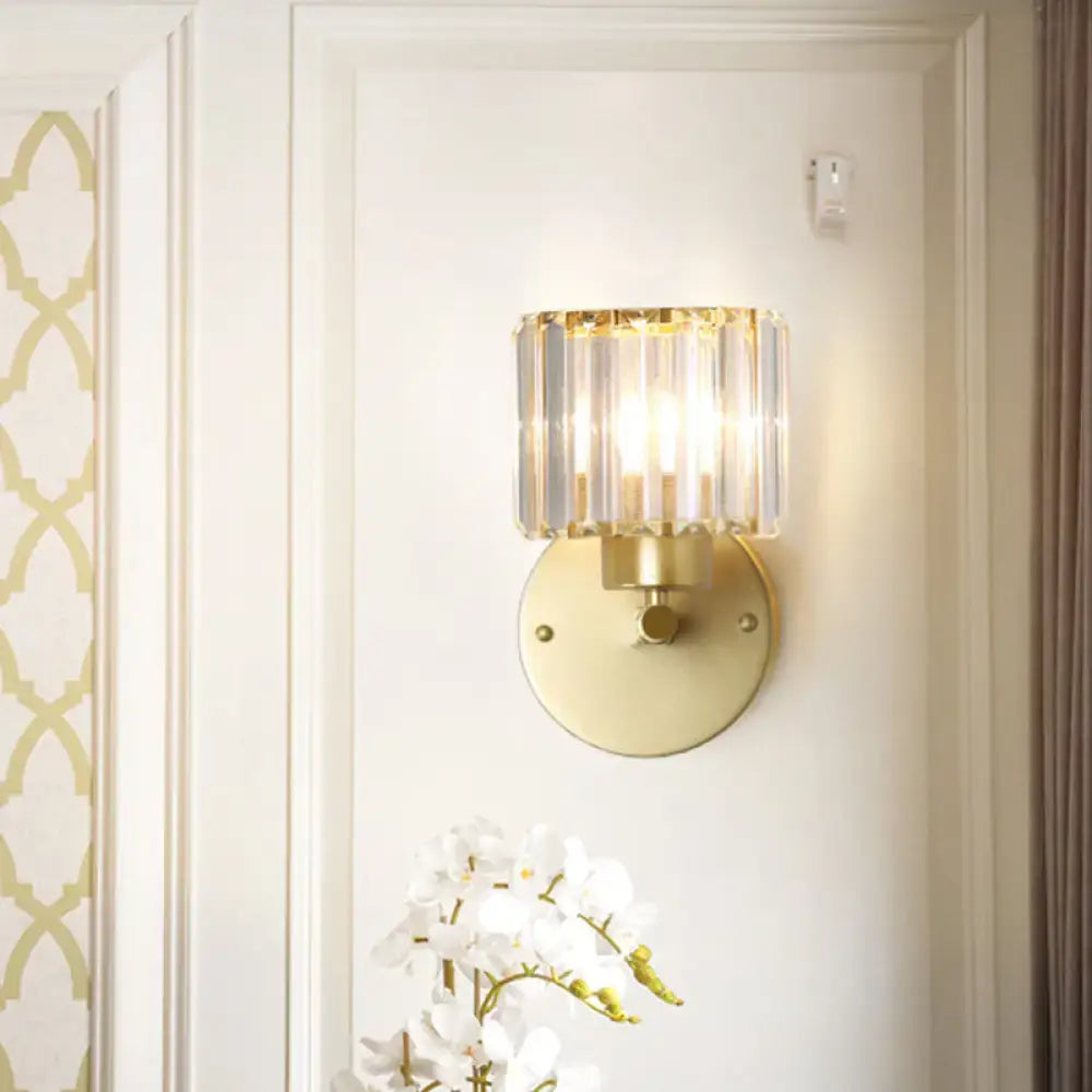 Postmodern gold wall lamp with prismatic crystal shade featuring a cylindrical crystal design for bedroom sconce lighting