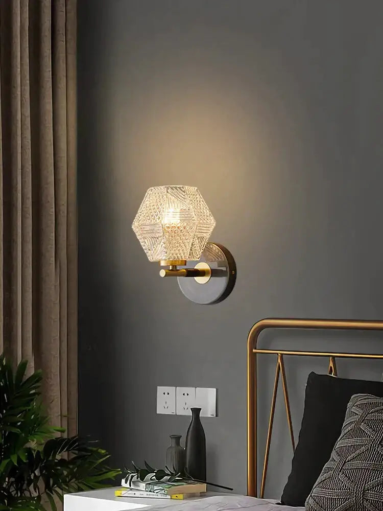 A postmodern luxury led wall lamp featuring a gold hexagonal crystal glass sconce with brass-finished metal base
