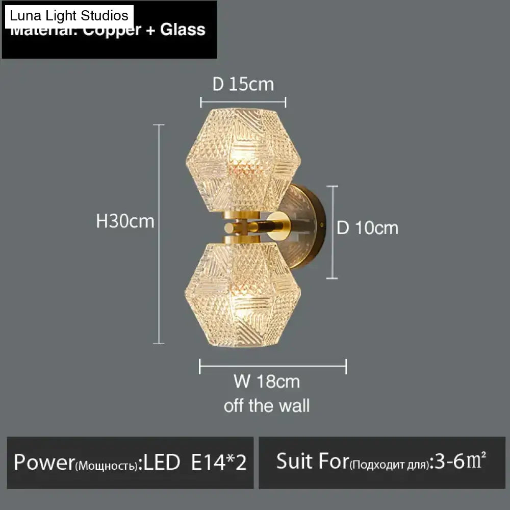 Gold-toned copper postmodern luxury led wall sconce with two hexagonal faceted glass shades for bedroom lighting