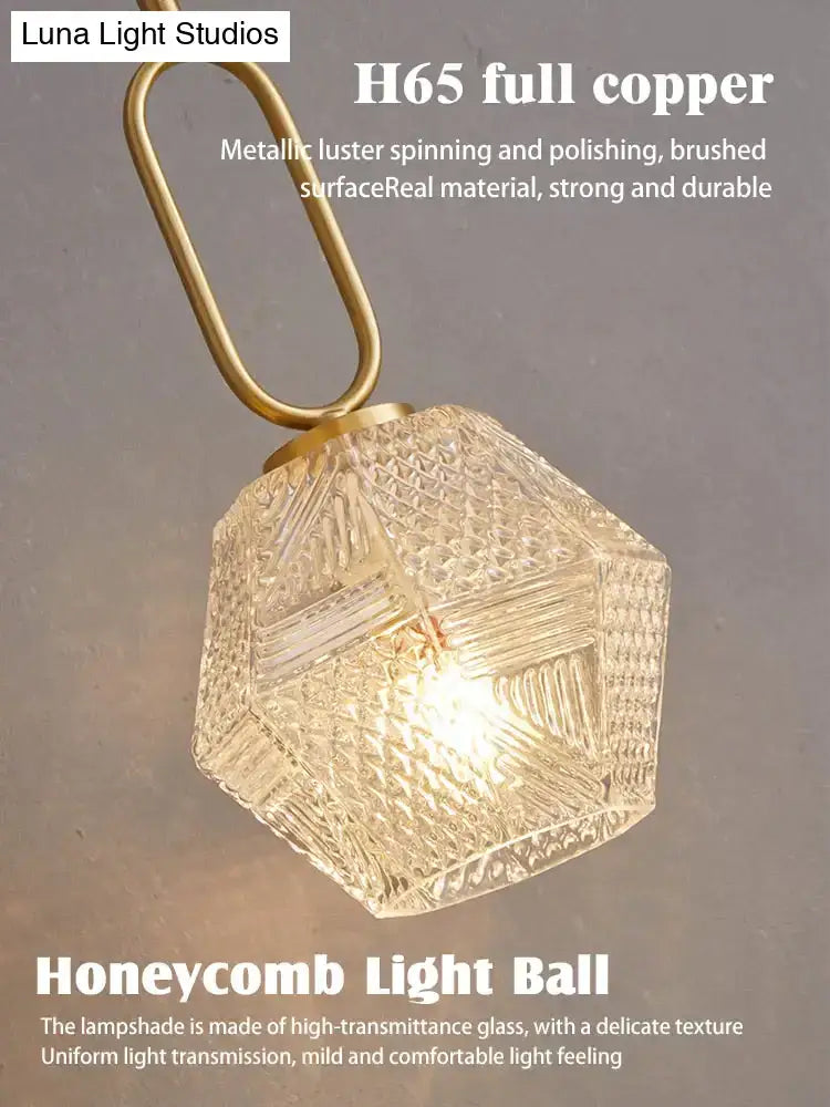 A postmodern luxury led wall lamp with a hexagonal honeycomb glass light ball and brushed brass copper fixture