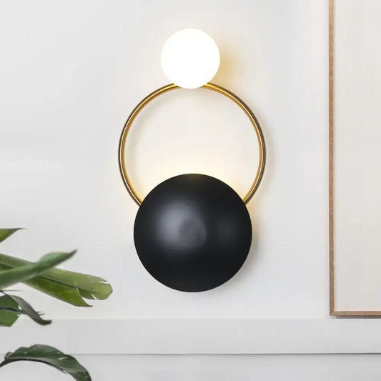 Postmodern orbital flush mount black and gold sconce with illuminated white globe and matte black shade for bedroom wall