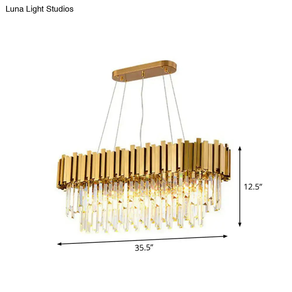 Gold-toned postmodern oval hanging light with vertical metallic bars and cascading crystal prisms for dining room island
