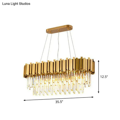 Gold-toned postmodern oval hanging light with vertical metallic bars and cascading crystal prisms for dining room island